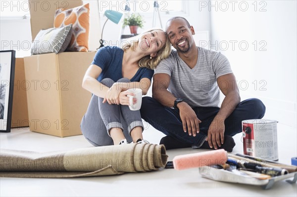 Portrait of couple taking break during apartment renovation.