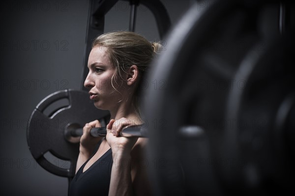 Young woman weightlifting in gym.