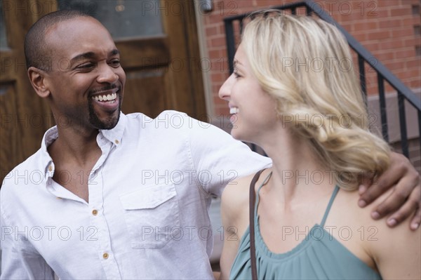 Smiling couple walking in residential district.