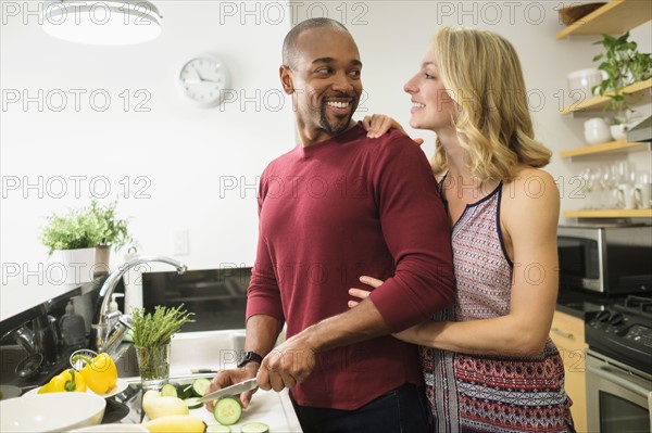 Couple preparing dinner in kitchen.