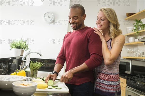 Couple preparing dinner in kitchen.