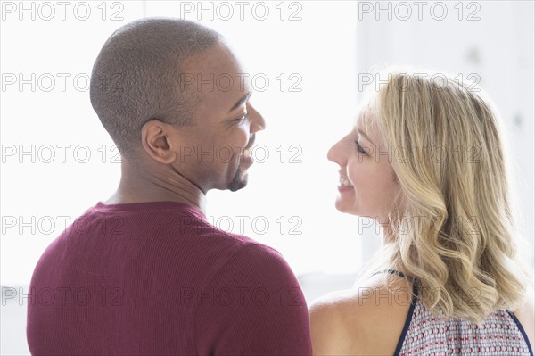 Happy multi ethnic couple looking at each other.