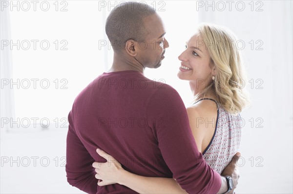 Happy multi ethnic couple looking at each other.