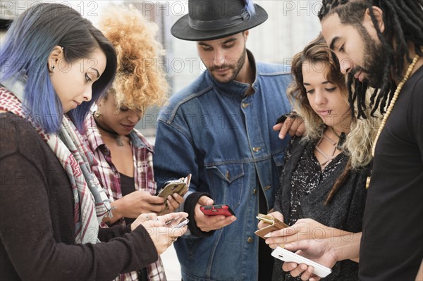 Young people outdoors using smartphones.