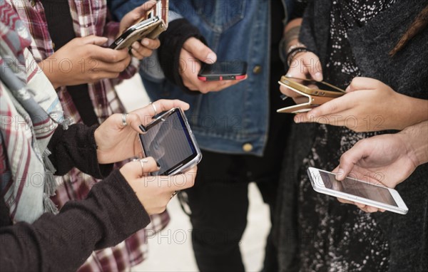 Young people outdoors using smartphones.