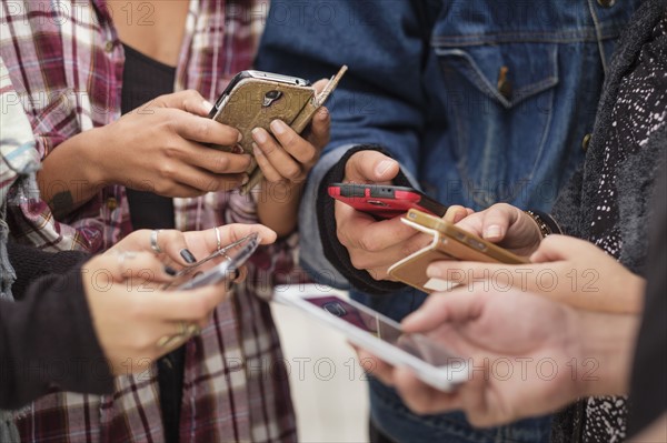 Young people outdoors using smartphones.