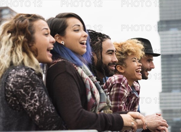 Friends in city looking at view, laughing.