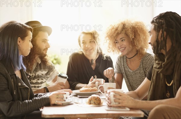 Friends having coffee together in cafe.