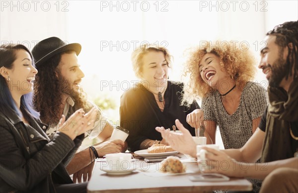 Friends having coffee together in cafe.