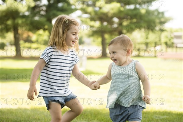 USA, Pennsylvania, Washington Crossing, Two sisters (18-23 months, 2-3) holding hands and walking together