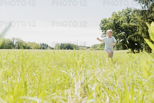 USA, Pennsylvania, Washington Crossing, Boy (4-5) running in green field