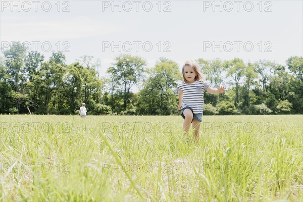 USA, Pennsylvania, Washington Crossing, Girl (2-3) and boy (4-5) walking on green field