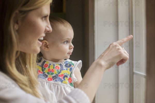 Mother and daughter (18-23 months) looking through window