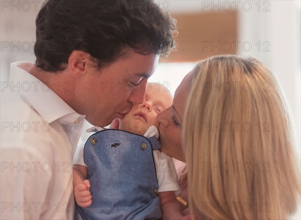 Couple kissing baby son (0-1 months)