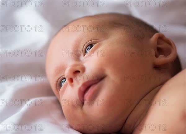 Baby boy (0-1 months) lying on bed