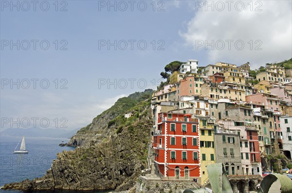 Italy, Cinque Terre, Riomaggiore, Multi colored buildings on hill by sea