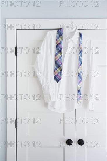 Shirt and tie hang on closet door