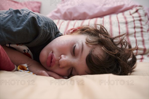 Boy (4-5) sleeping in bed