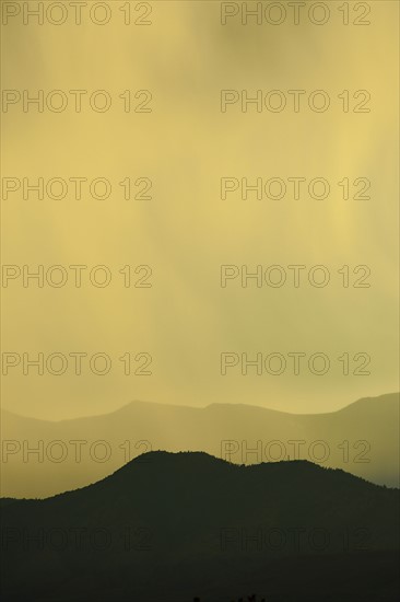 USA, Colorado, Denver, Rain against colorful sky above rocky mountains