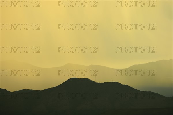 USA, Colorado, Denver, Rain against colorful sky above rocky mountains