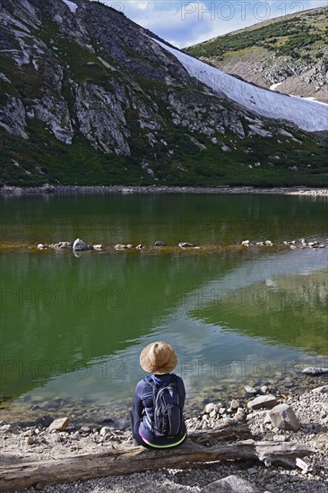 USA, Colorado, Idaho Springs, Hiker sitting by lake below Saint Mary's Glacier