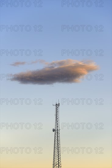 Cloud over communication tower at dusk