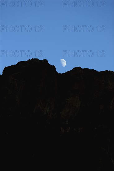 USA, Colorado, Moon over silhouette of rocks in Roxborough State Park