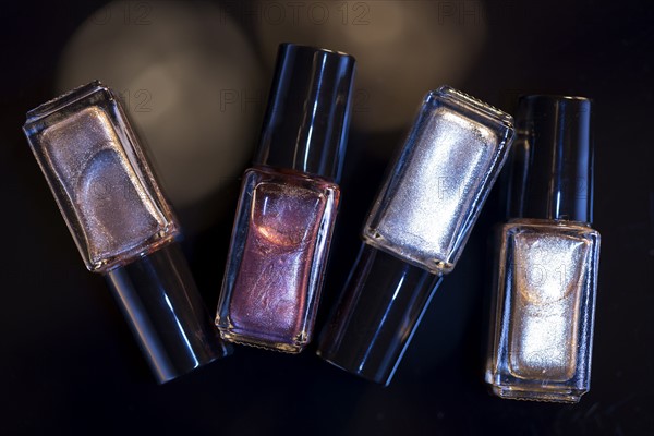 Bottles of nail polish against black background