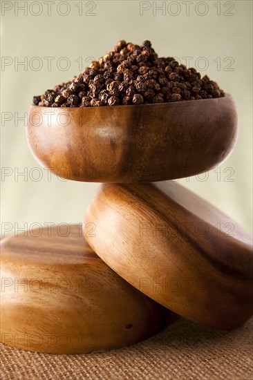 Peppercorns in wooden bowl