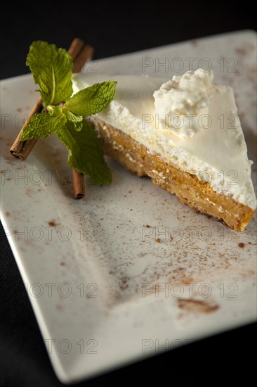 Pumpkin pie with cinnamon on white plate