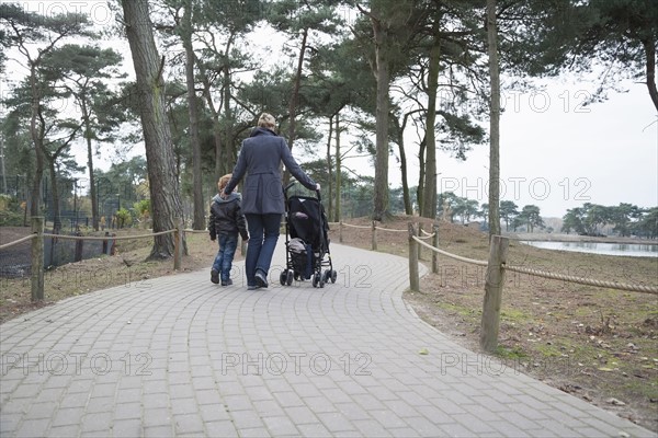 Rear view of mother and son (8-9) walking on path