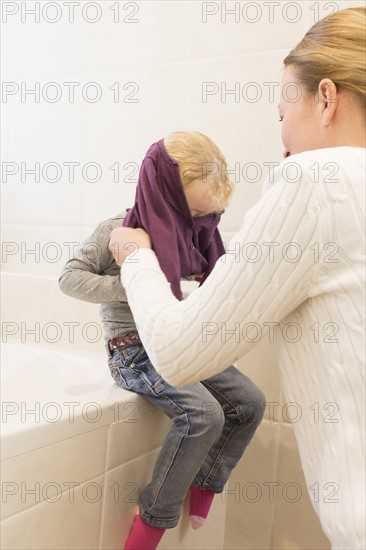 Mother dressing daughter (4-5) in bathroom