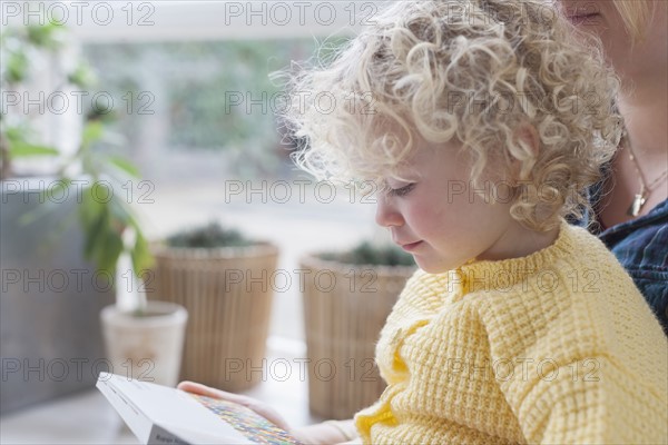 Mother and daughter (4-5) reading book