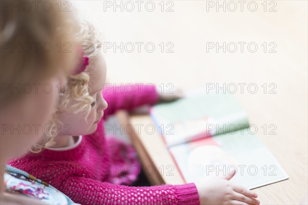 Mother and daughter (4-5) reading book