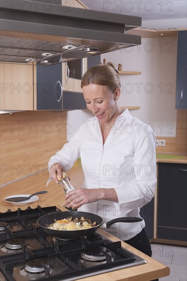 Woman salting scrambled eggs