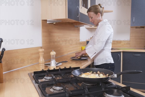 Woman preparing scrambled eggs for breakfast