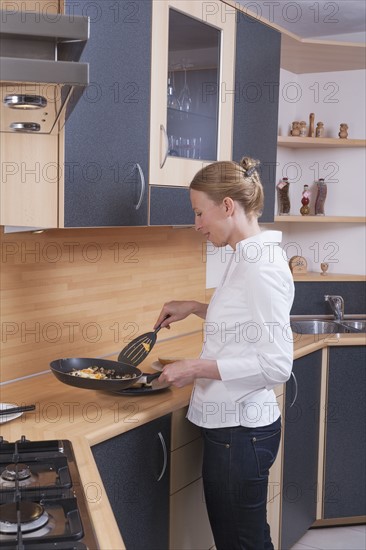 Woman preparing scrambled eggs for breakfast