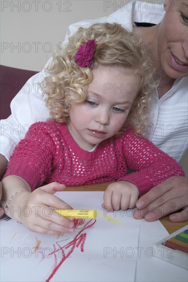 Mother and daughter (4-5) drawing with crayons