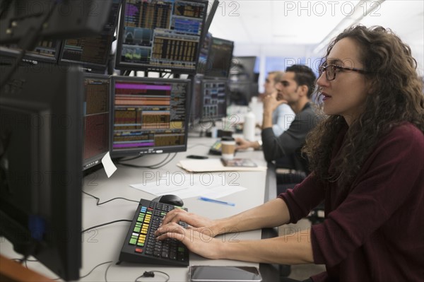 Young traders analyzing computer data.