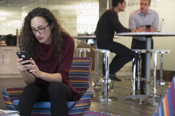 Young woman using mobile phone in common area.