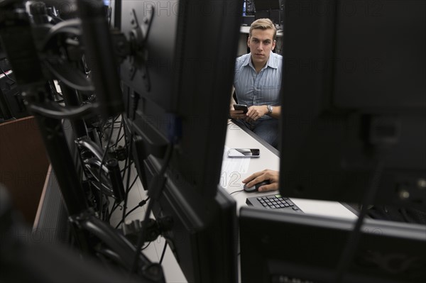 Young traders analyzing computer data.