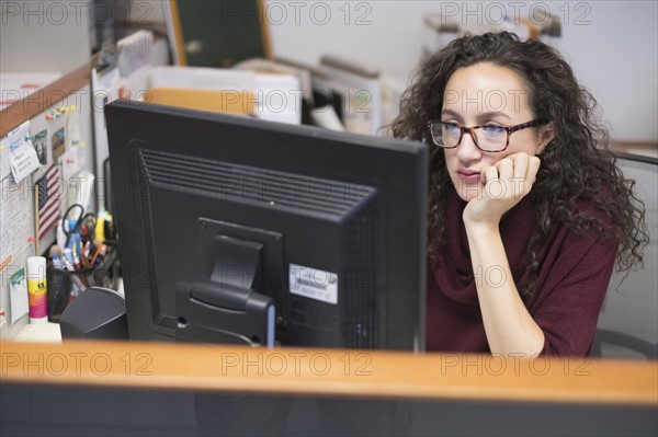 Young woman looking at computer monitor.