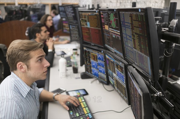 Young traders analyzing computer data.