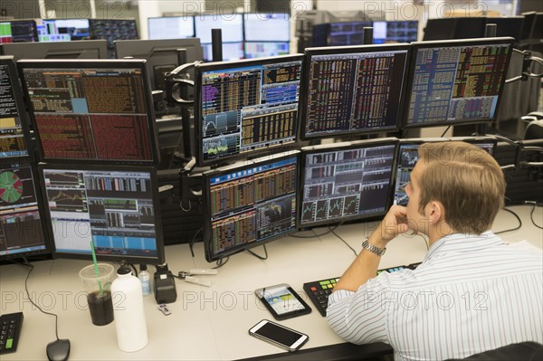 Young trader analyzing computer data.