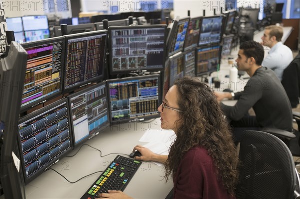 Young traders analyzing computer data.