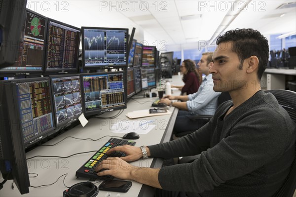 Young traders analyzing computer data.