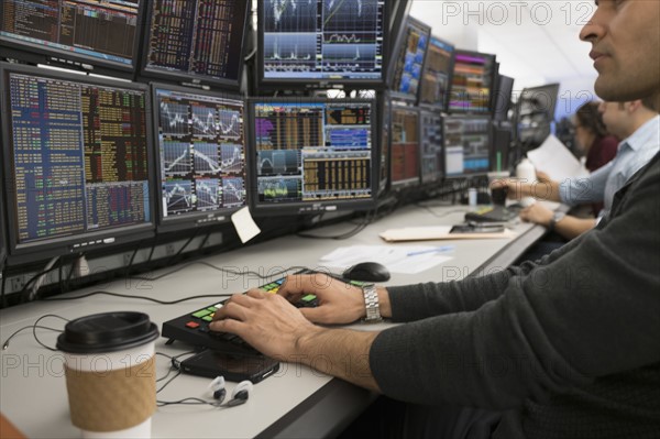 Young trader typing on computer.