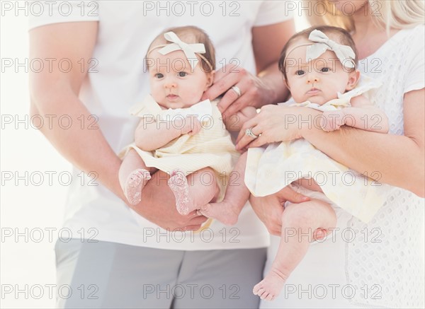 Studio shot portrait of two baby girls (2-5 months) with parents