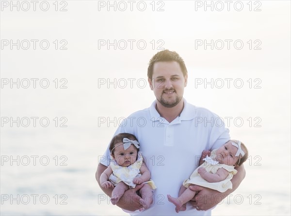 Happy father holding babies (2-5 months)