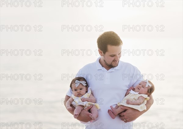 Happy father holding babies (2-5 months)